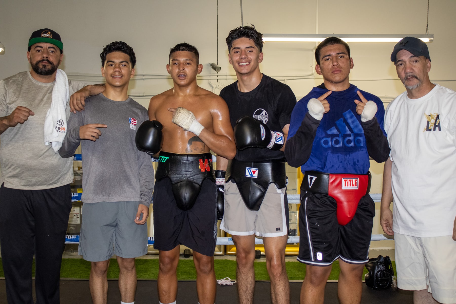 Six people gathered beside the boxing ring